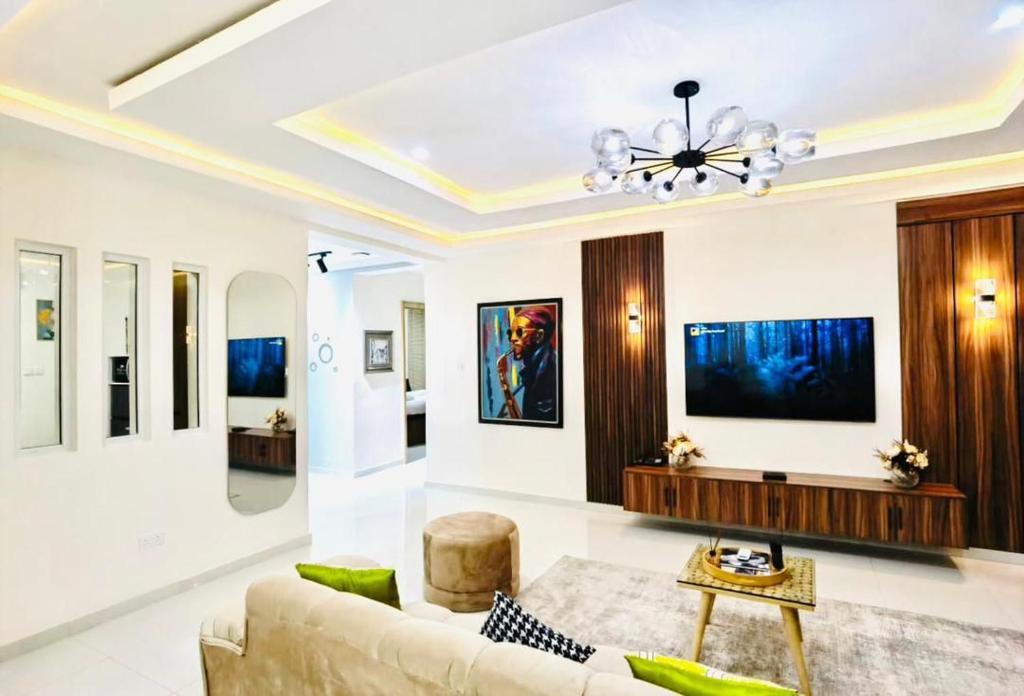 a living room with a couch and a chandelier at One Bedroom Apartment in Ikoyi Lagos in Ikoyi