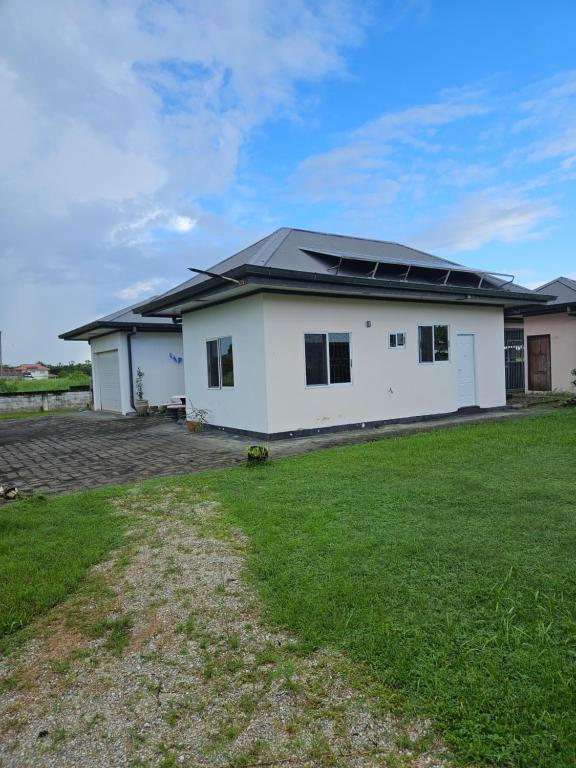 Casa blanca con paneles solares en el techo en Jagtlust, en Meerzorg