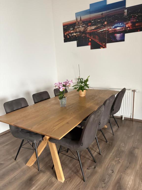 a wooden table in a room with chairs around it at Wunderschöne Wohnung in Erftstadt-Liblar 15 Minuten bis zum Phantasialand! in Erftstadt