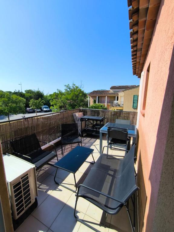 d'une terrasse avec des chaises et des tables sur un balcon. dans l'établissement Appartement T2 entre Roche et Mer, à Roquebrune-sur Argens