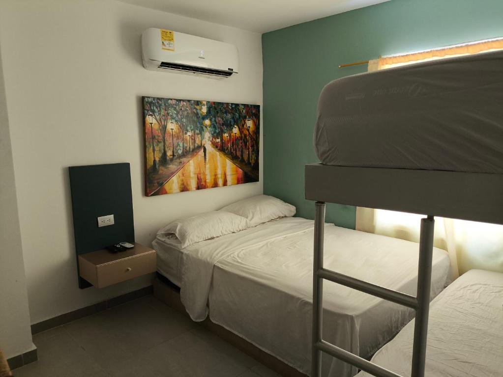 GairaGaira Hotel Meraki的卧室配有双层床,墙上挂有绘画作品