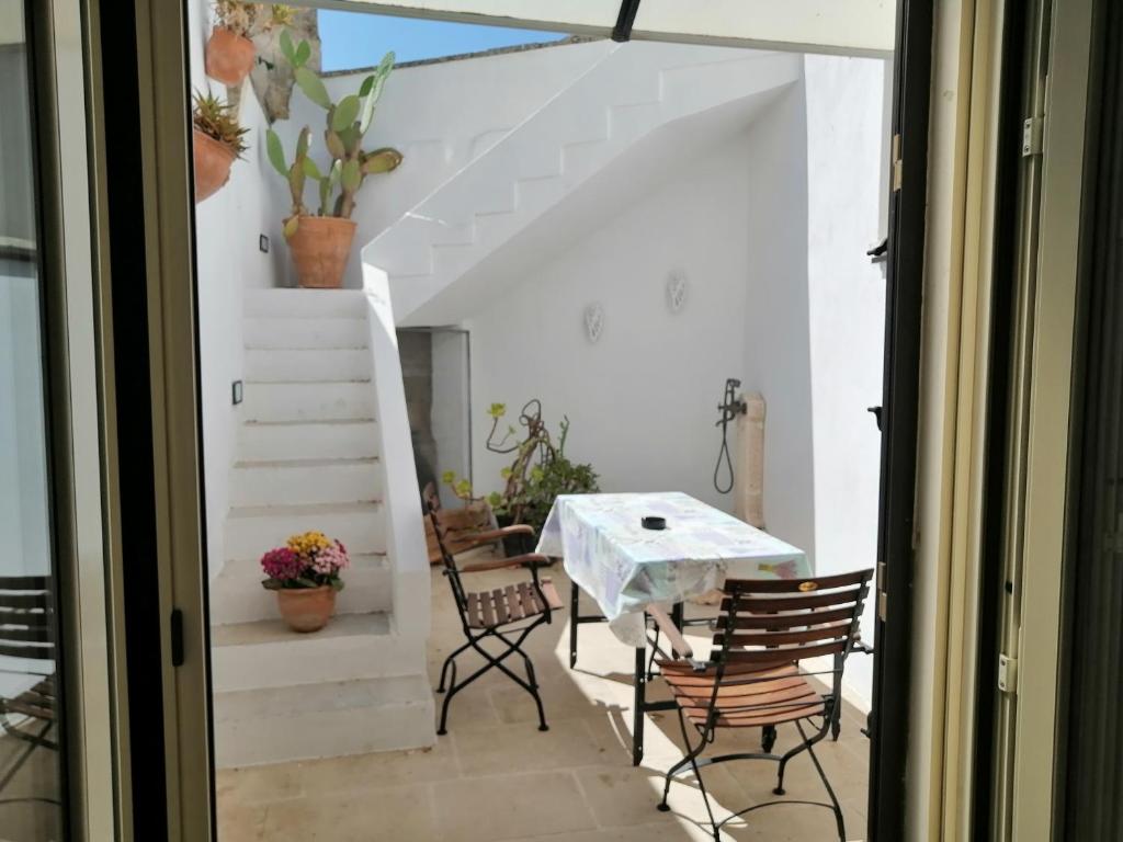 a patio with a table and chairs and stairs at A casa di Marisa in Casamassella
