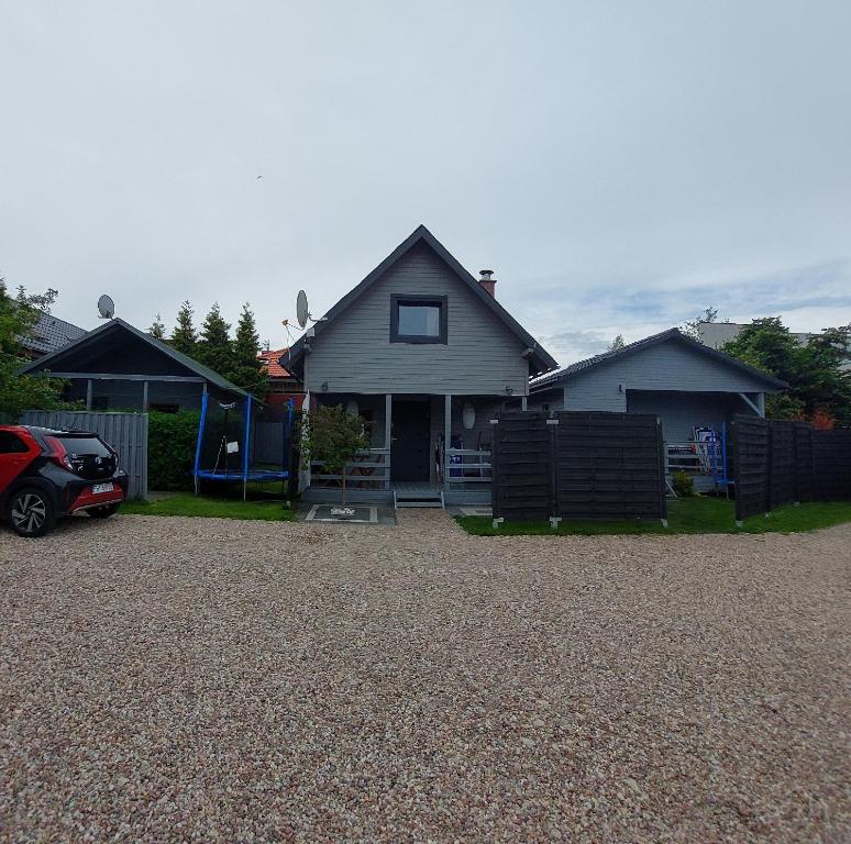 a house with a car parked in a driveway at Domki Morska in Rewa
