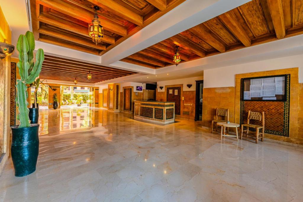 un grand hall avec une plante en pot et une table dans l'établissement Top localisation, neuf, Piscine et une vue balcon, à Marrakech