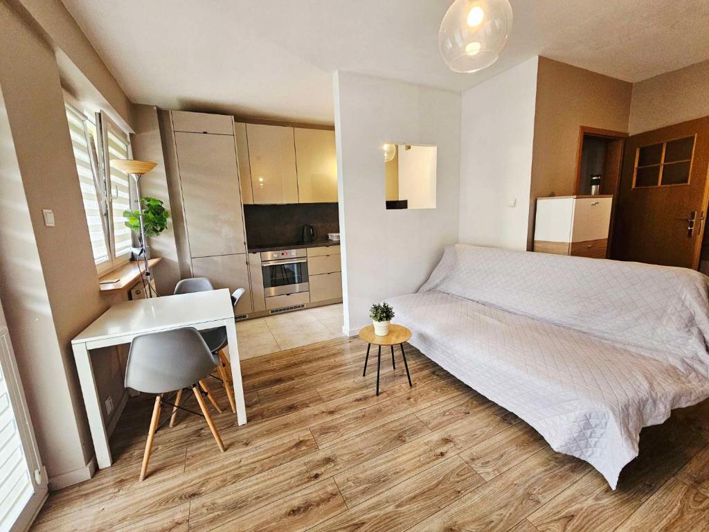 ein Schlafzimmer mit Bett und Schreibtisch und eine Küche in der Unterkunft Green Kabaty Apartment 5 in Warschau
