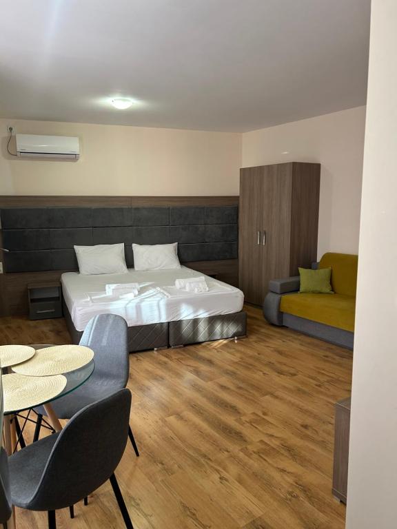 una camera da letto con un letto, un tavolo e delle sedie di Судио Диксан a Pomorie