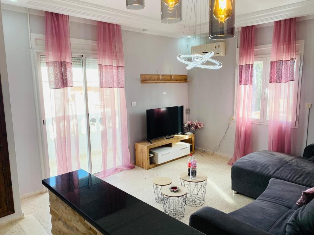 a living room with a couch and a tv at Dar Misk Elil in Bizerte