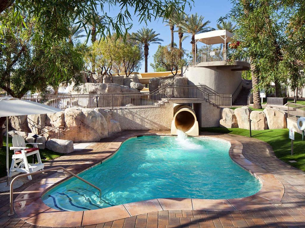 a swimming pool with a waterfall in a backyard at The Westin Mission Hills 2BR Apartment with Resort Access in Rancho Mirage
