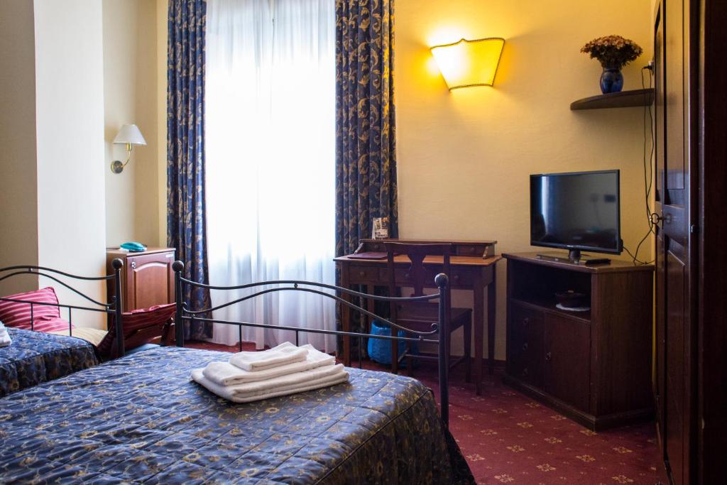 um quarto de hotel com uma cama e uma televisão em Hotel Parco Fiera em Turim
