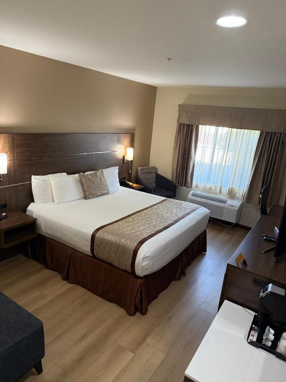 Postel nebo postele na pokoji v ubytování Evergreen Inn & Suites