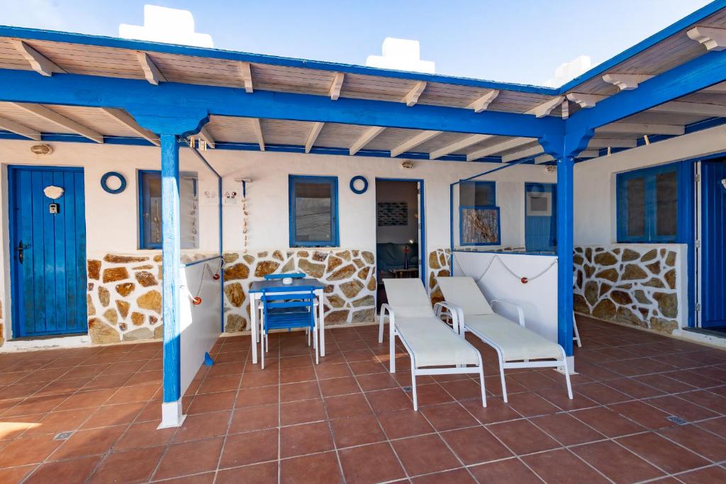 a patio with chairs and a table and a blue ceiling at Ventanas de Lanzarote in Playa Quemada