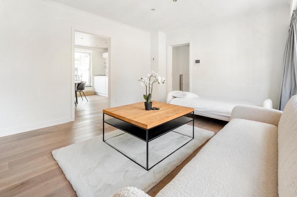 a living room with a table and a couch at Luxury apartment x big terrace in Sint-Niklaas