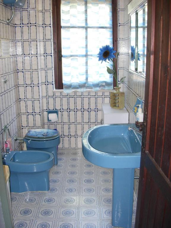 łazienka z błękitną umywalką i toaletą w obiekcie Villa Ro w mieście Porto Columbu - Perdʼe Sali