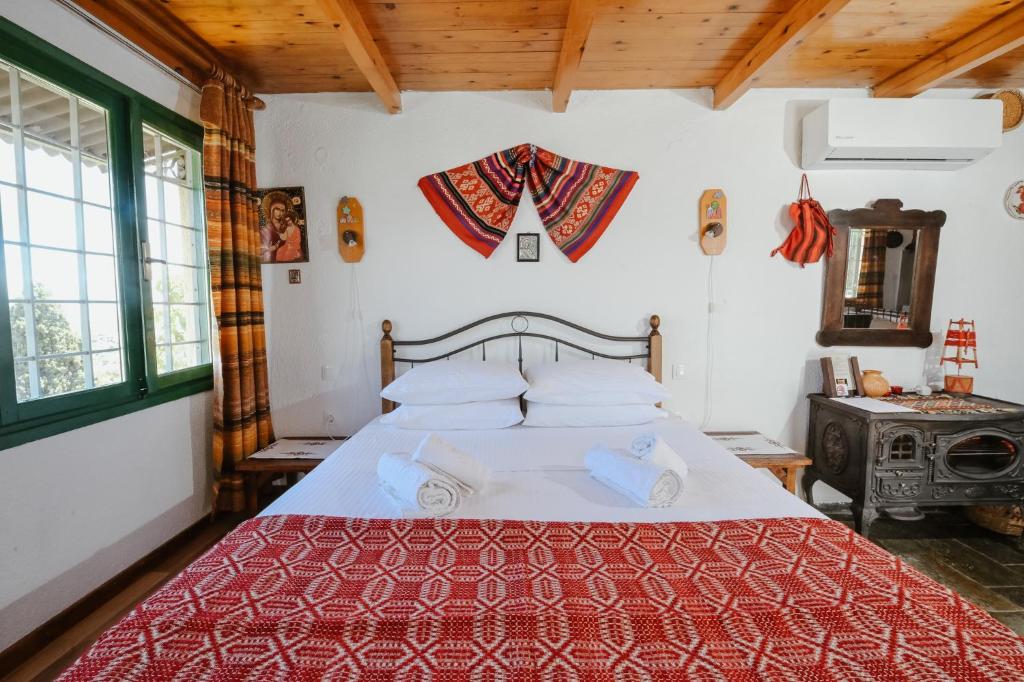 a bedroom with a bed with a red and white bedspread at Villa Kamari- Stunning Views in Kritsá