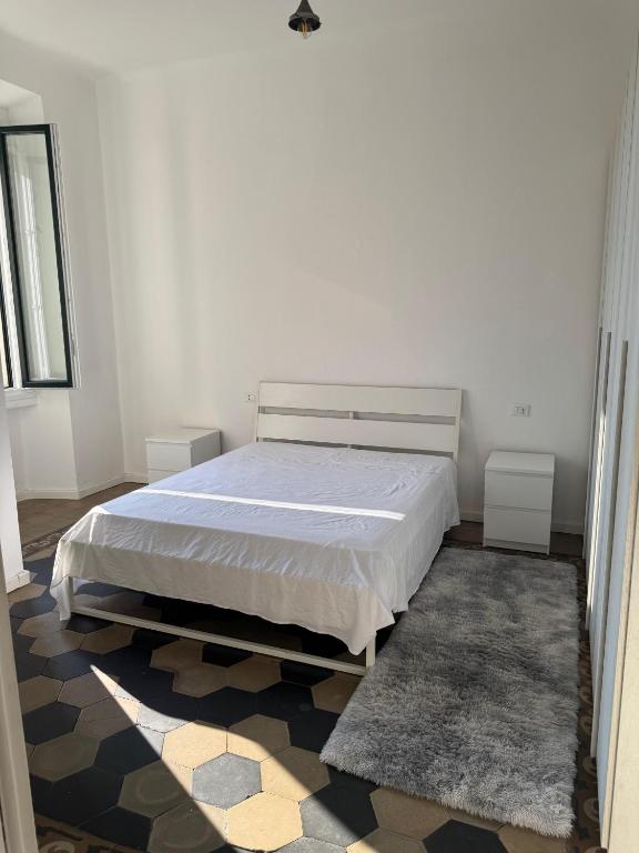a white bedroom with a bed and a rug at Appartamento Duomo-Sempione in Milan