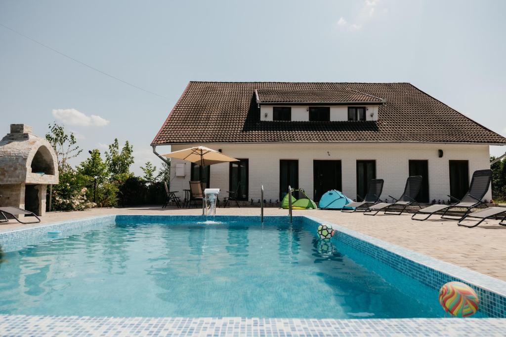 a swimming pool in front of a house at Pensiunea Oaza Padurii in Novaci