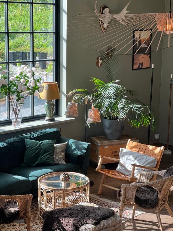 a living room with a green couch and a table at Hotell Åre Fjällsätra in Undersåker