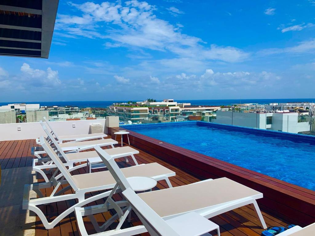 a balcony with chairs and a swimming pool on a building at Piedra Azul in Playa del Carmen