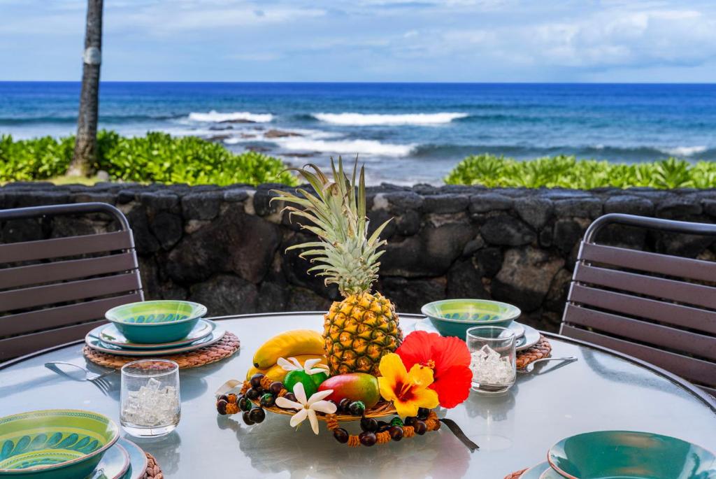 una mesa con un bol de fruta en la parte superior del océano en Kona Reef A6, en Kailua-Kona