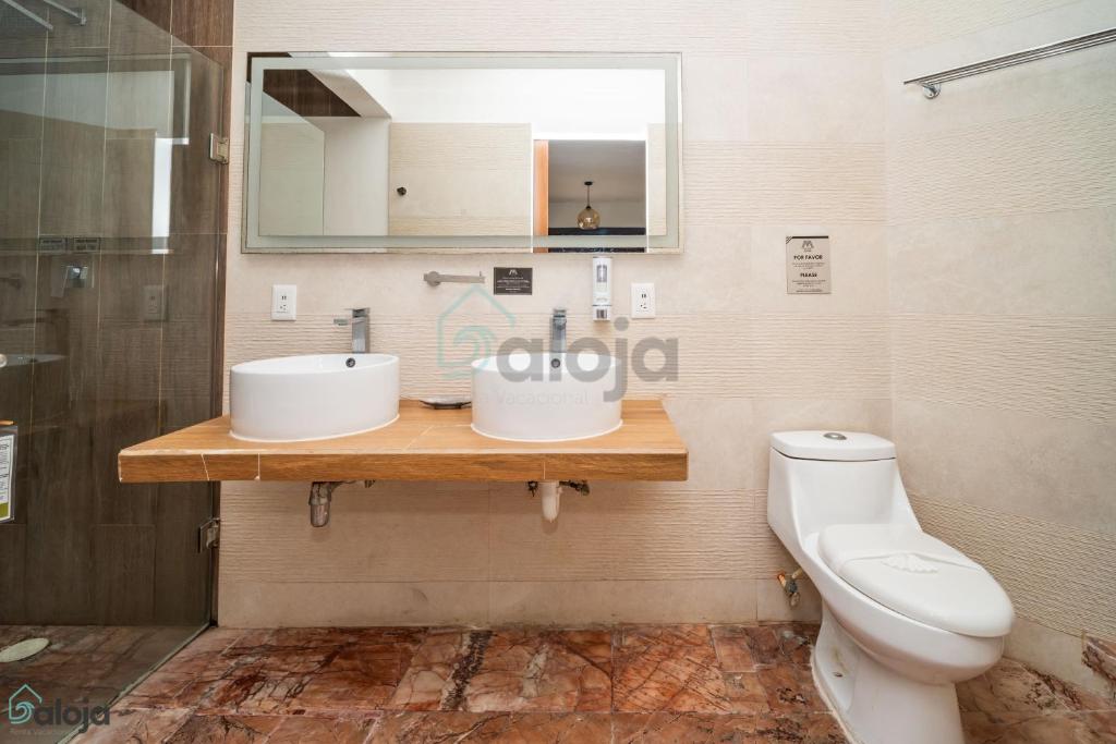 a bathroom with two sinks and a toilet at Cierre propiedad in Cancún