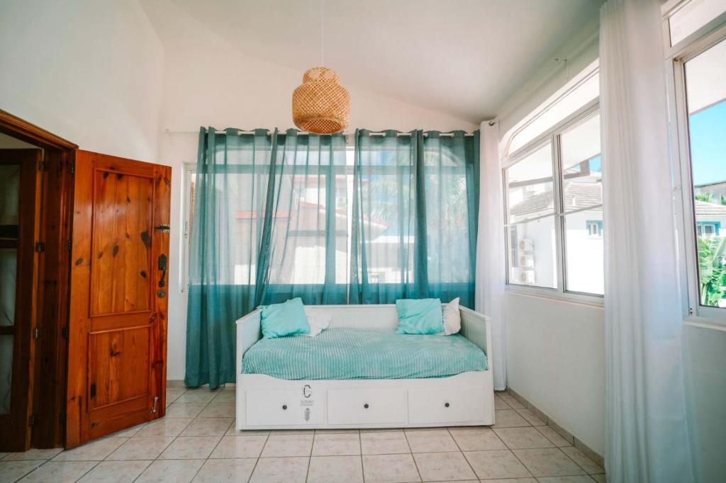 a bedroom with a bed with blue sheets and a window at Sueño Caribeño in La Laguna