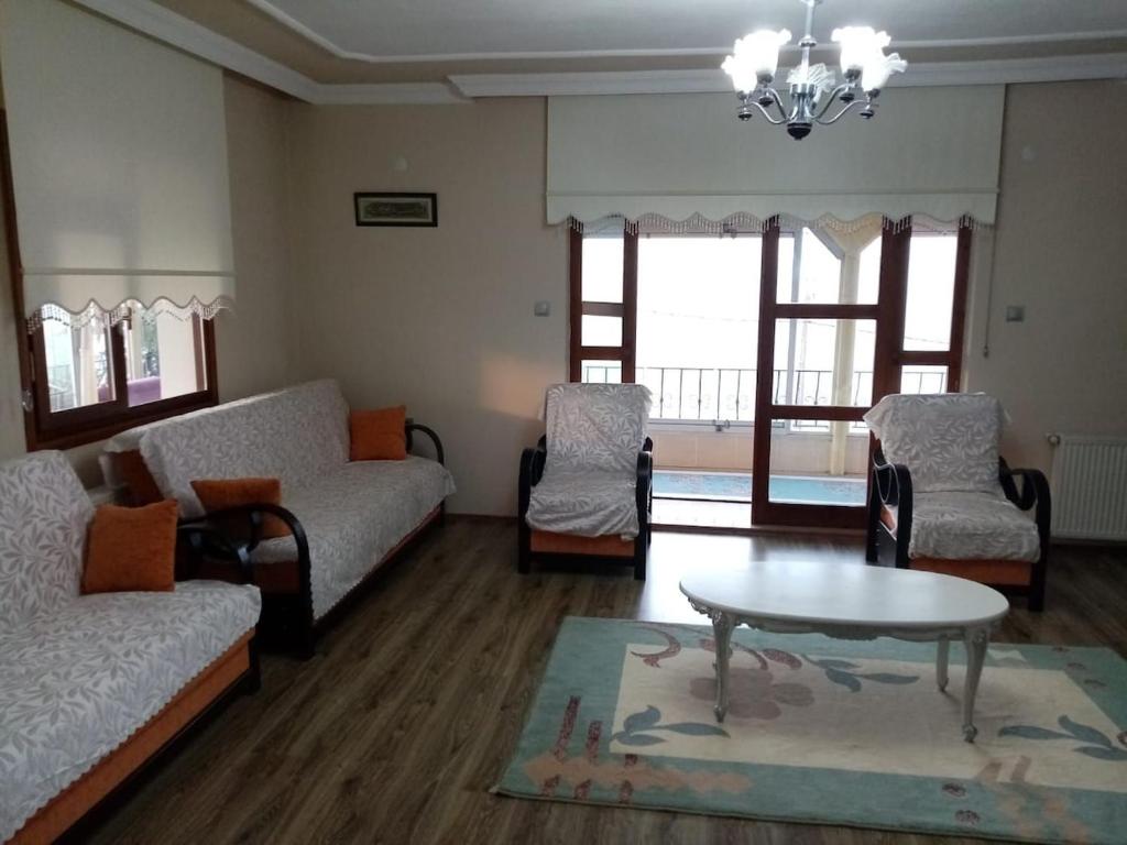 a living room with a couch and a table and chairs at Trabzon Gürbulakta kiralık villa in Trabzon