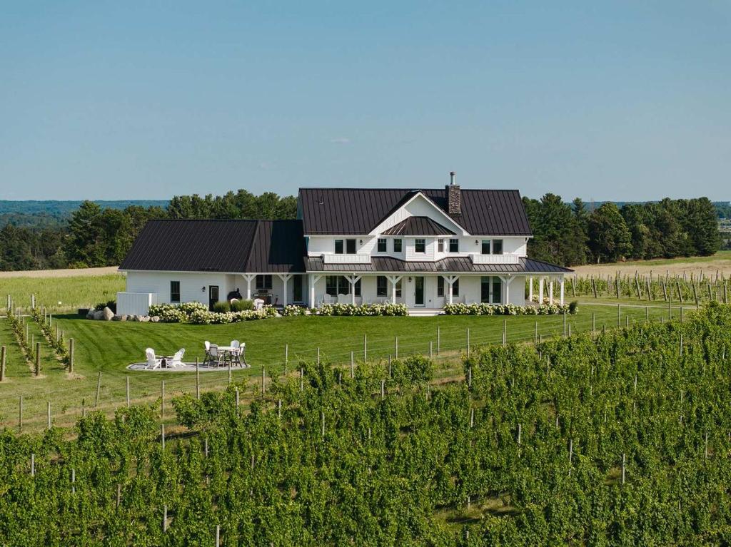 WilliamsburgにあるAnn Riley Farmhouse - Vineyard by Traverse Cityのブドウ畑の大白い家