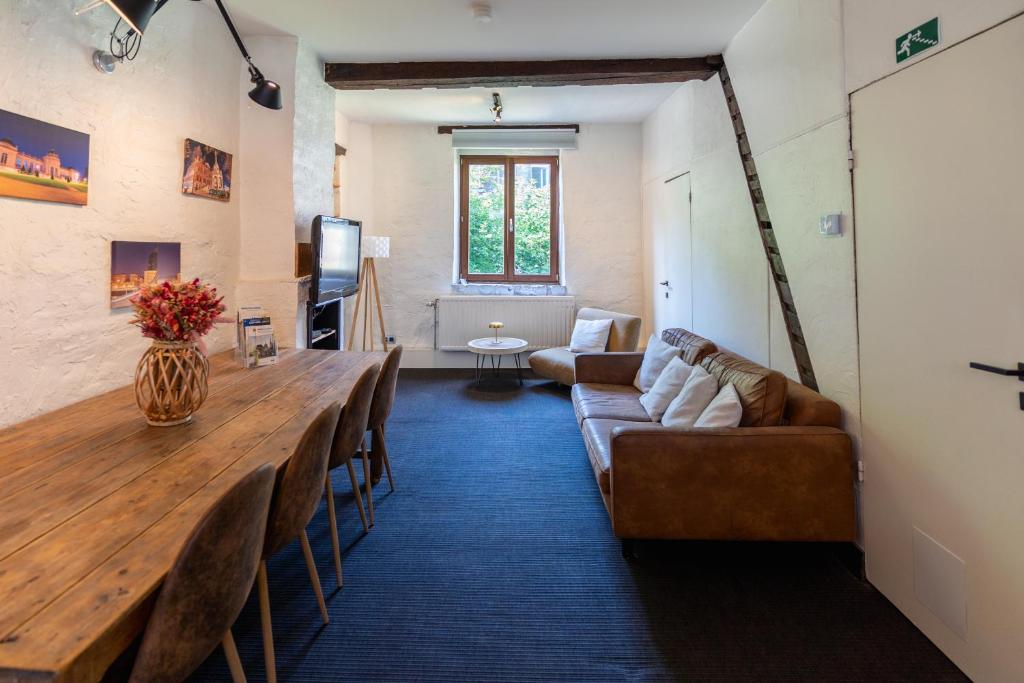 a living room with a long table and a couch at Appartement atypique - coeur historique de Liège in Liège