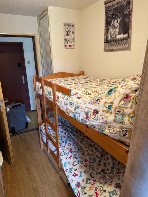 a bedroom with a bed with a comforter at Studio à la montagne meublé et entièrement équipé in Bellevaux