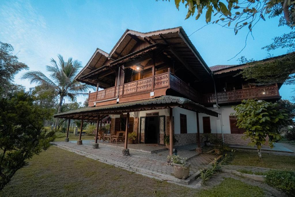 a house with a wooden roof with a porch at Sawah Indah View Guesthouse in Timbanglawang