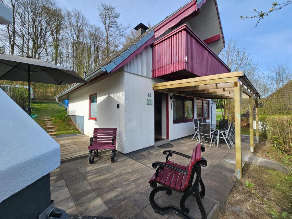 a patio with two benches and an umbrella at Ferienhaus Steffi in Kirchheim