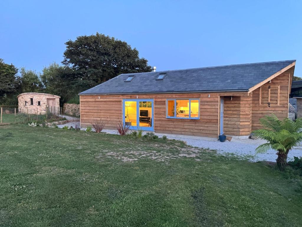 a small wooden house with a grass yard at Ocean Heart Studio- Luxury, Rural Retreat in Wendron