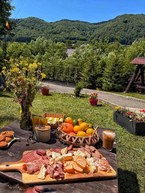 a table with a plate of food and a basket of fruit at Vila Aldor in Bran