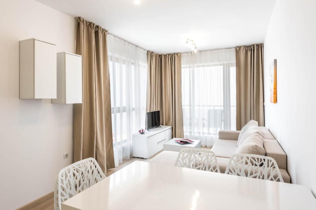 a white living room with a white table and chairs at Copacabacum Sea View in Varna City