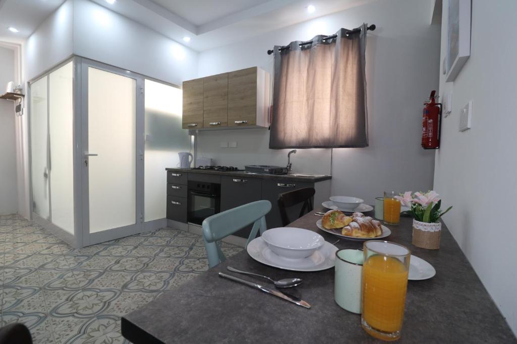 una cocina con una mesa con platos de comida. en La Corte Trihouse 3 bedrooms, en Żabbar