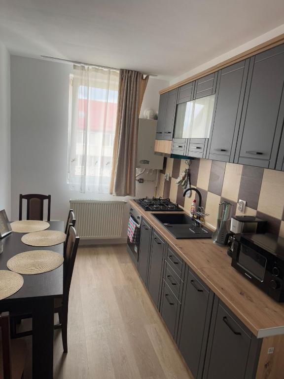 a kitchen with a table and a stove top oven at The Urban Hero Appartment in Floreşti