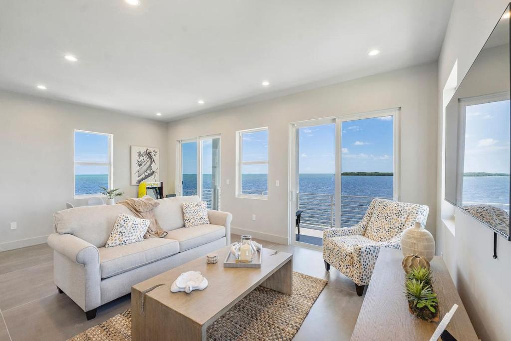 a living room with a couch and chairs and the ocean at Chic Ocean Hideaway with Grill in Key Largo