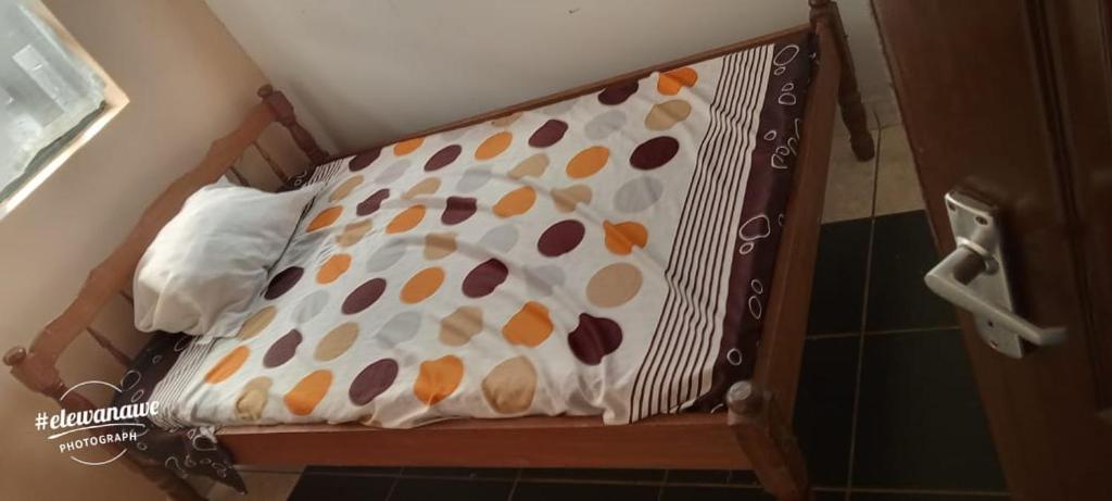 a bed with a polka dot sheet on it at BEN's Arnb in Gatunga