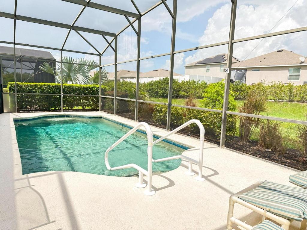 a swimming pool with a chair and a table at 5 bedrooms pool home Calabay in Davenport