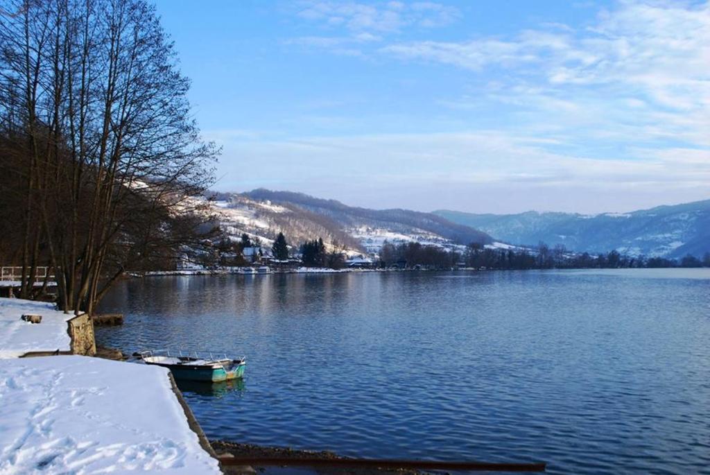a lake with a small boat in the water at Hotel Royal Drina in Mali Zvornik