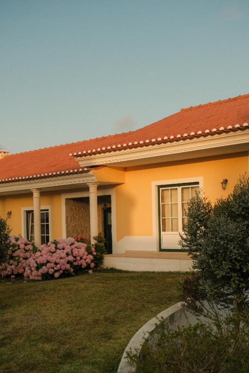 a small yellow house with a red roof at Quinta Amarela in Nazaré
