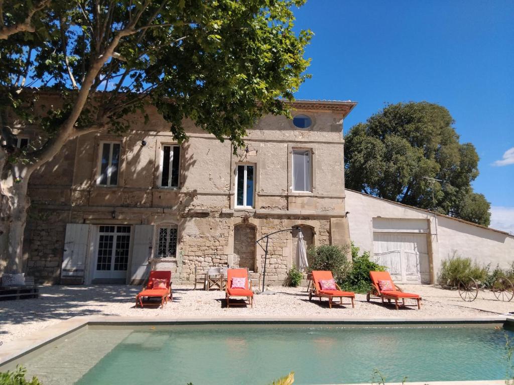 une maison avec piscine devant un immeuble dans l'établissement Ancien Couvent avec piscine entre Alpilles et Camargue pour 10 personnes, à Arles