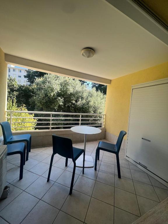 een kamer met een tafel, stoelen en een raam bij Bilocale Le Furama in Antibes