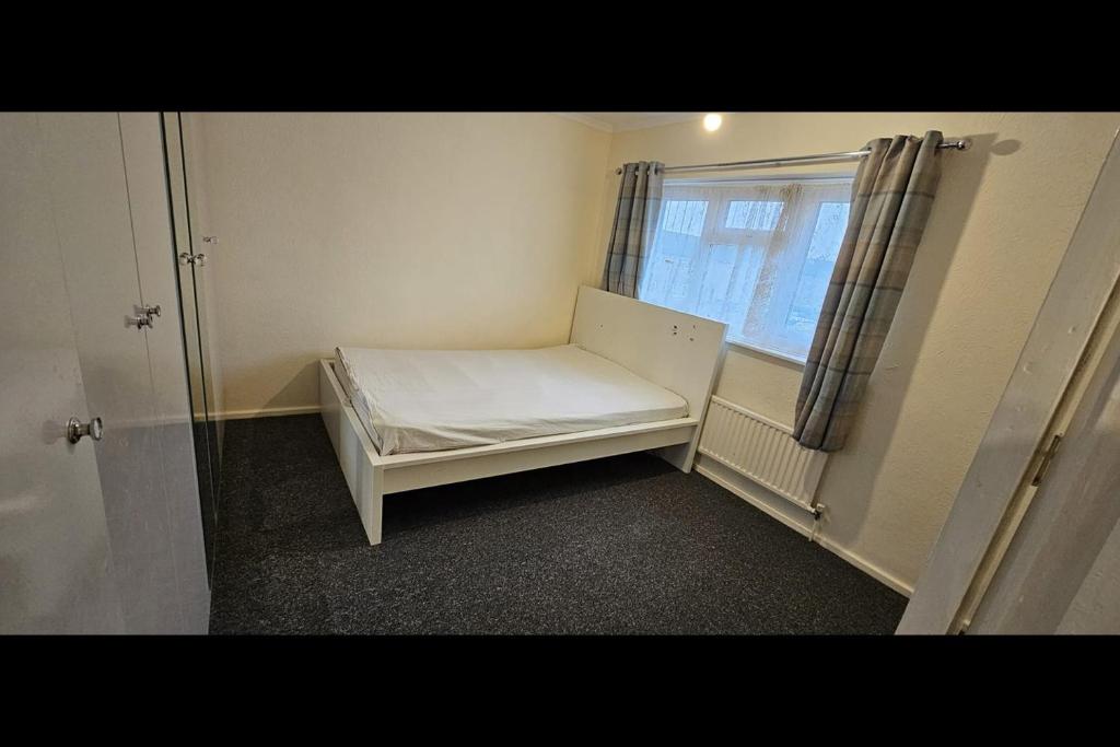 ein kleines Zimmer mit einem Bett und einem Fenster in der Unterkunft Beautiful Tilbury House in Tilbury