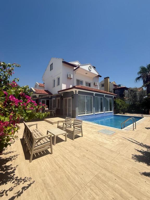una casa con piscina y 2 bancos en Villa Papatya, en Fethiye