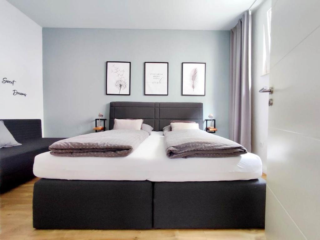 ein Schlafzimmer mit einem großen Bett in einem Zimmer in der Unterkunft Flair-Apartments 'Apartment nähe Schlosspark', 300 m Bahnhof, Innenstadt Bad Salzuflen Stadtteil Schötmar, für Urlaub oder Geschäftsreise, separater Eingang, 24 Std Check-in,WLAN, Streaming-Fernseher, Küche, Regendusche, Doppelbett, 2 Schlafsofa in Bad Salzuflen