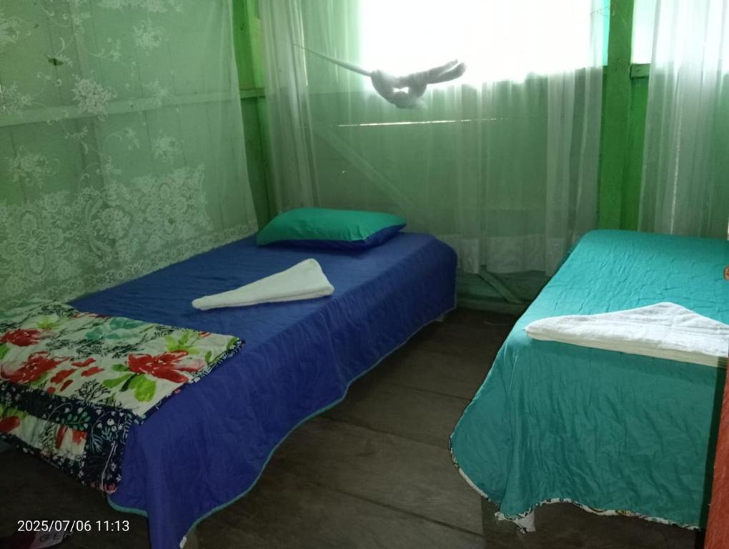 a room with two beds and a bird flying overhead at Atacuari Salvaje Tours Amazonas in San Juan de Atacuari