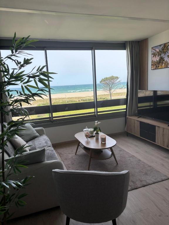 a living room with a couch and a table at Élégant T2 acces direct plage in Saint-Cyprien-Plage