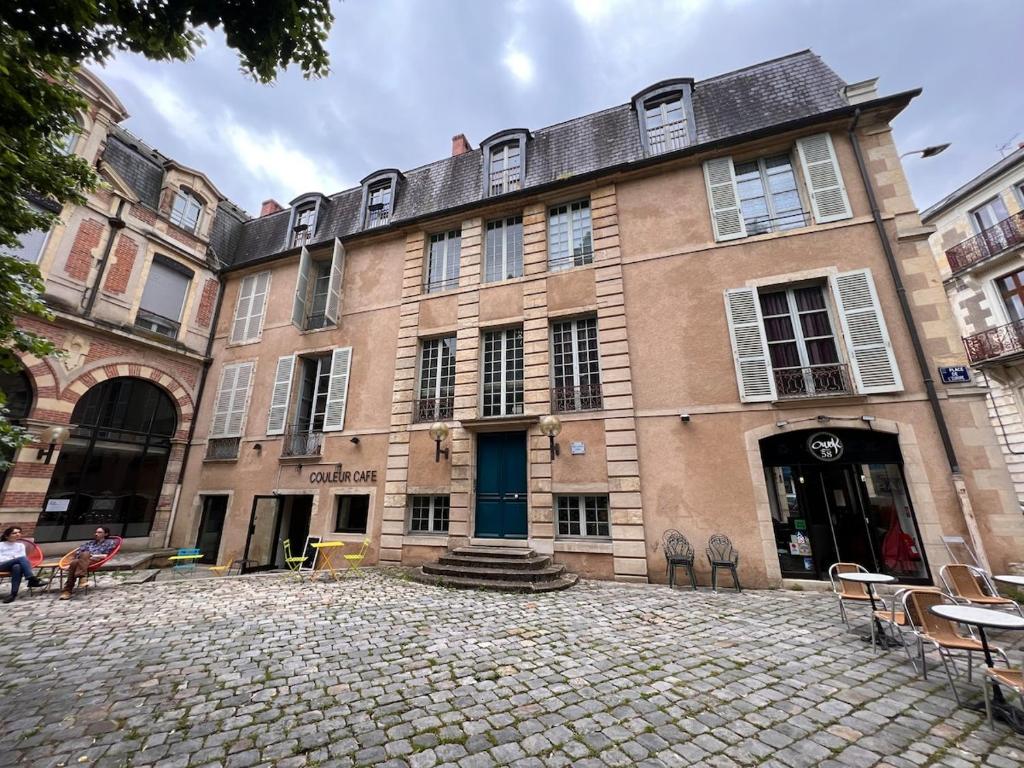 ein großes Backsteingebäude mit einer blauen Tür in der Unterkunft Design studio, luxury and comfort in La Celle-sous-Gouzon