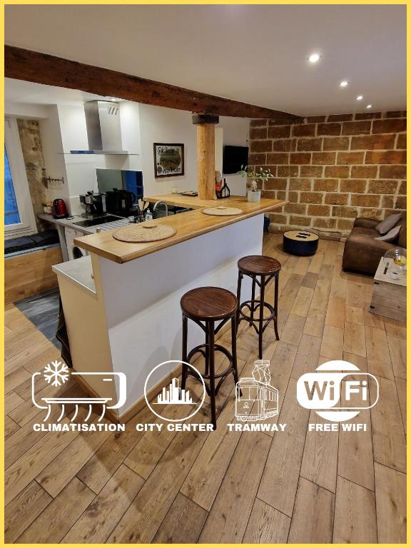 une cuisine avec un comptoir et deux tabourets dans l'établissement Le Chapeau Rouge - Centre Historique - Corum - Tramway - Climatisation, à Montpellier